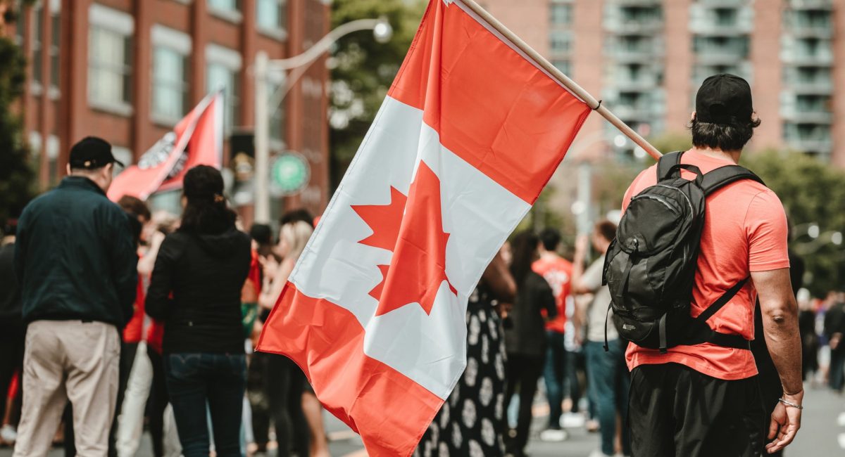 man-standing-with-a-canadian-flag